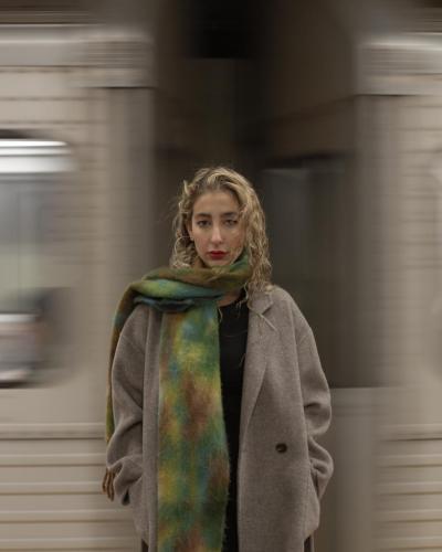 A girl in the subway crossing behind her