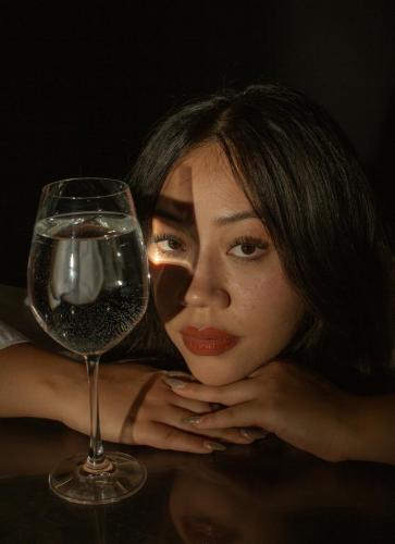 A Girl leaning with a glass shining through her eyes