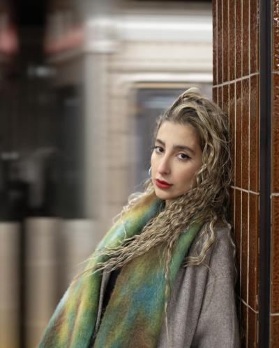 A Girl leaning against subway pillar