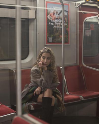 A girl sitting on subway seats meditating